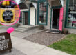storefront with vibrant pink door and an open sign on the sidewalk with pink balloons, Inset picture shows facial scrub jar